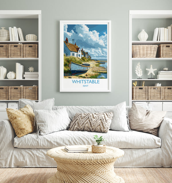 a living room with a white sofa, a coffee table, and a framed poster of a coastal village on the wall.