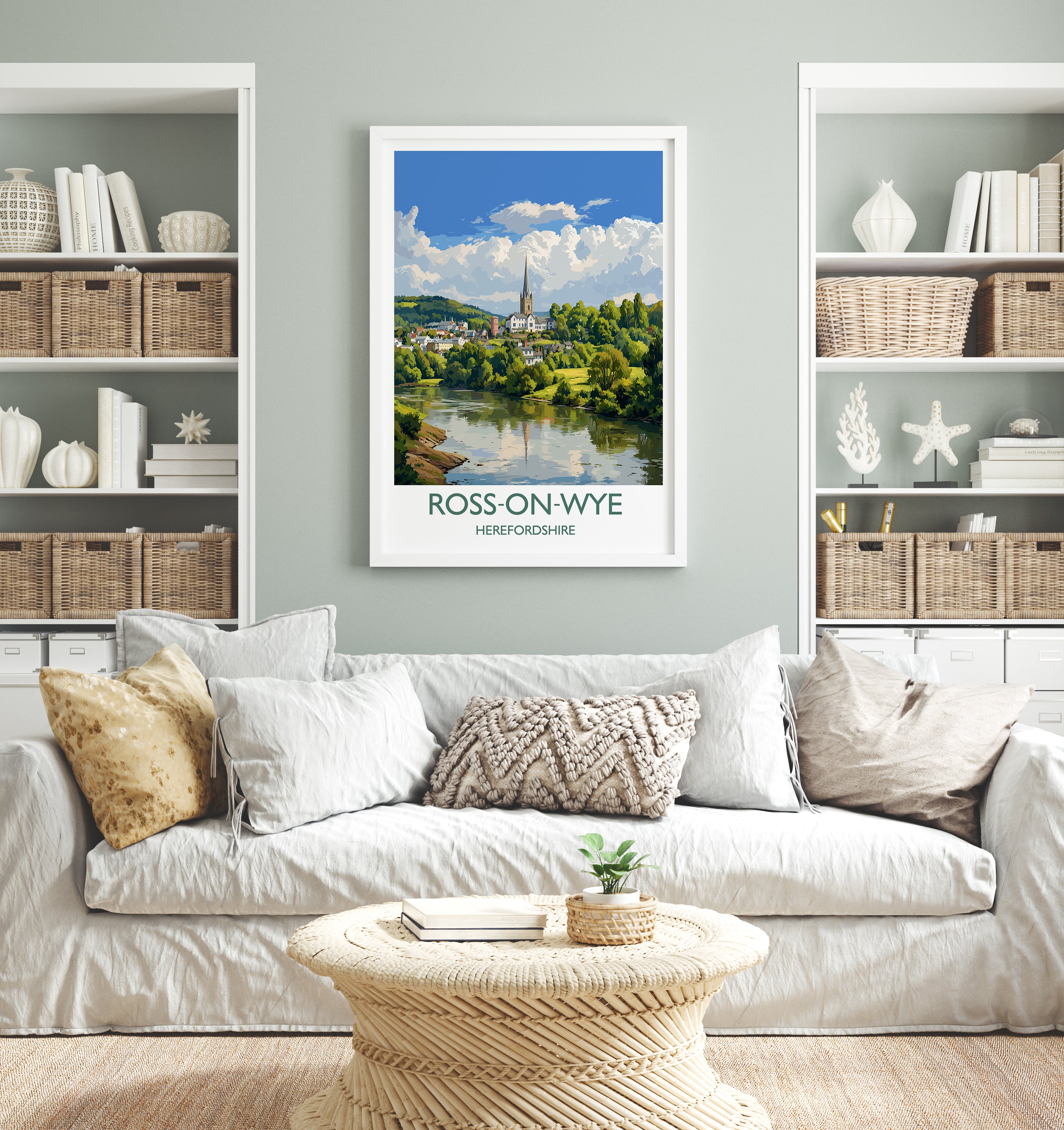 a living room with a white sofa, a coffee table, and a framed poster of a scenic view of Ross-on-Wye, a town in the Hebrides of Scotland.