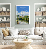 a living room with a white sofa, a coffee table, and a framed poster of a scenic view of Ross-on-Wye, a town in the UK.
