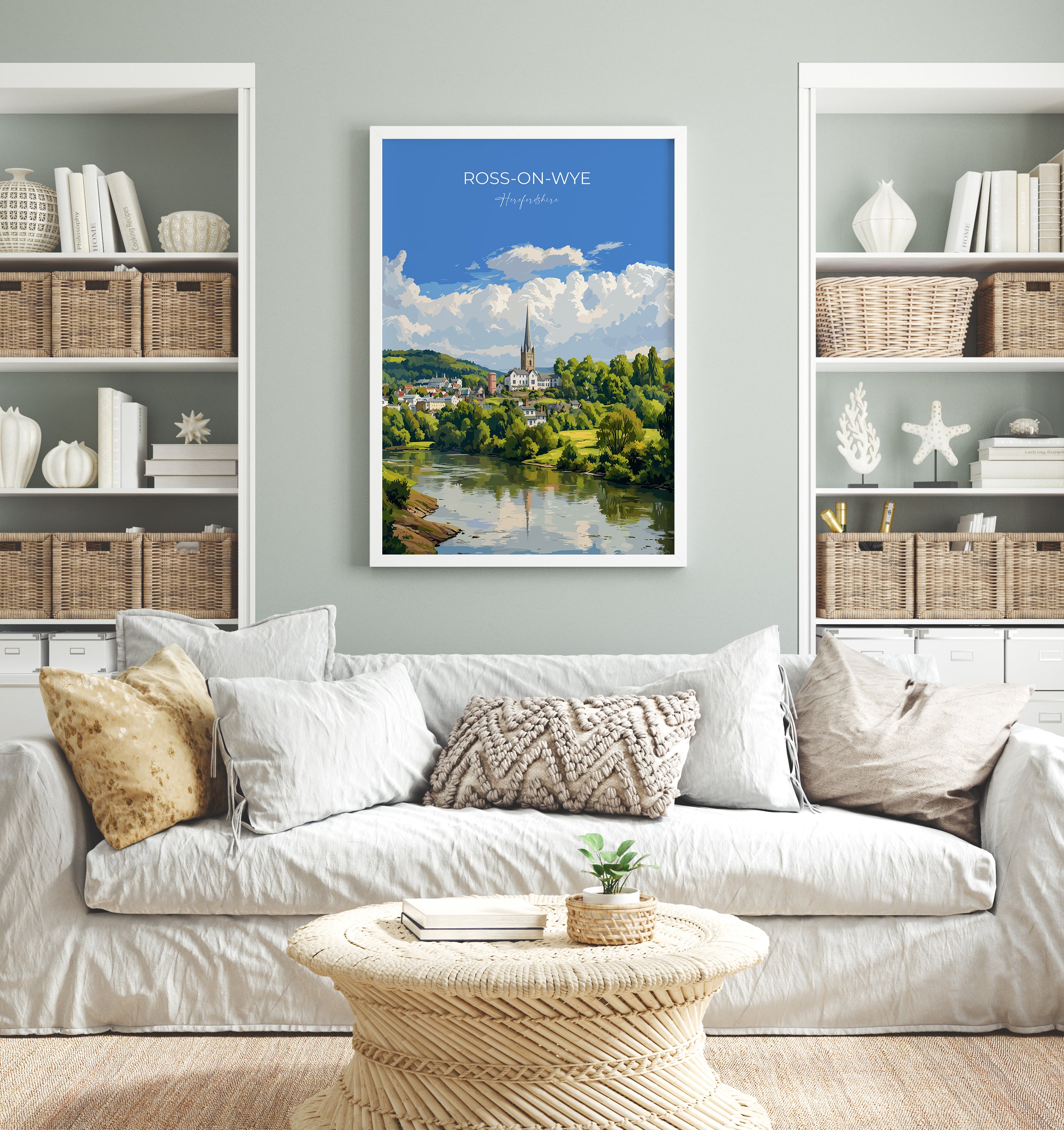 a living room with a white sofa, a coffee table, and a framed poster of a scenic view of Ross-on-Wye, a town in the UK.
