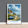 A framed painting depicting a coastal village in Whitstable, Kent, with houses, boats, and a beach in the background.