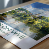 A printed poster or booklet featuring a scenic landscape with a castle or cathedral in the background, surrounded by trees and a body of water.