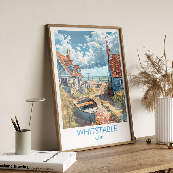 A framed poster of a coastal village in Kent, England, featuring a boat on the shore and colorful houses along the beach.