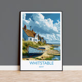 A framed painting depicting a coastal village in Whitstable, Kent, with houses, boats, and a beach in the background.
