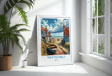 A framed poster of a coastal town in Kent, featuring a boat on the shore and colorful buildings.