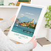 a person holding up a picture of lake garda